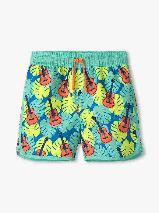 Promotes kids' swim sale category. Showing turquoise boys' swim shorts with tropical leaves and guitar print.