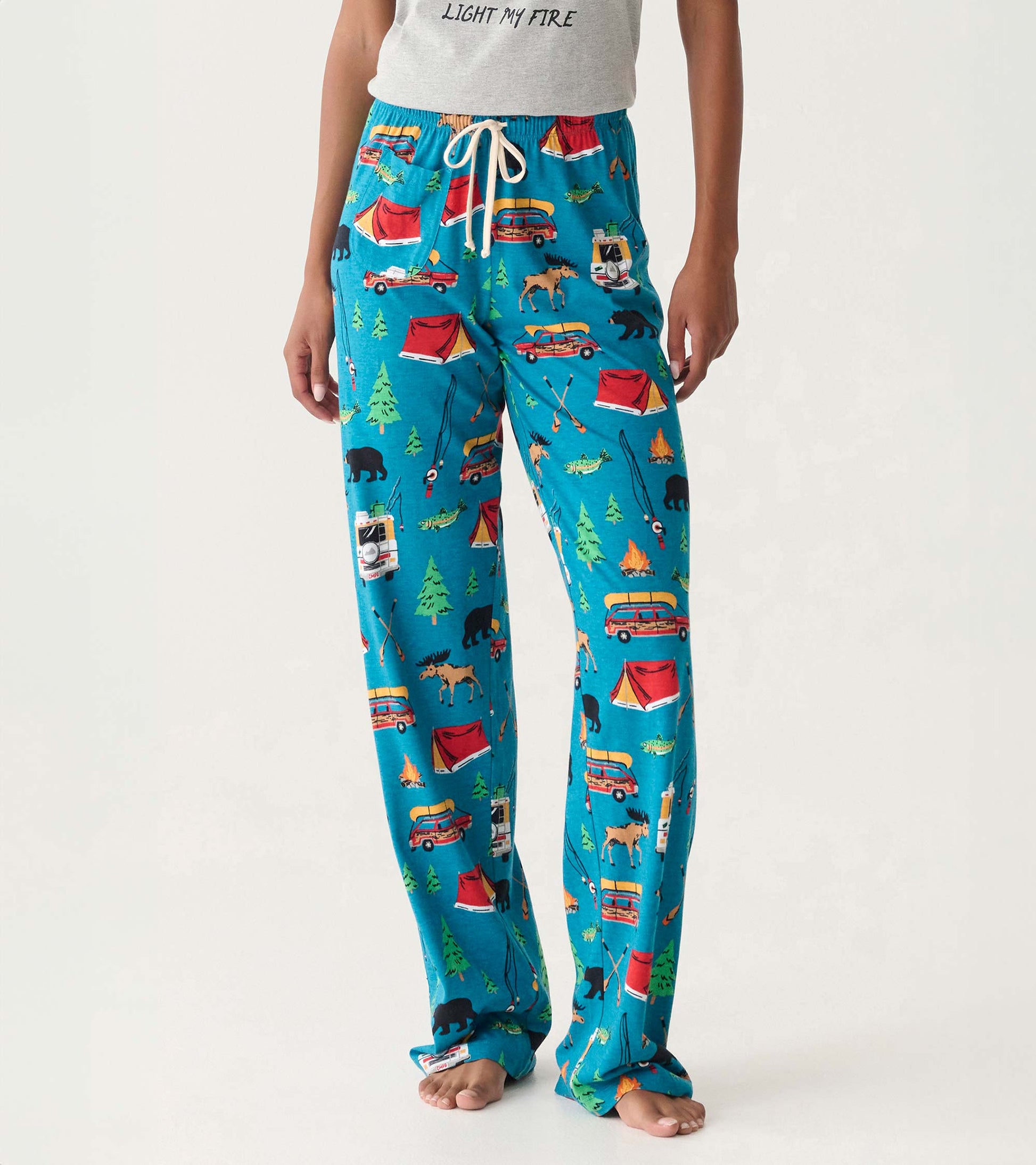 Blue cotton pajama pants with camping-themed print, drawstring waist, and straight legs, worn front view