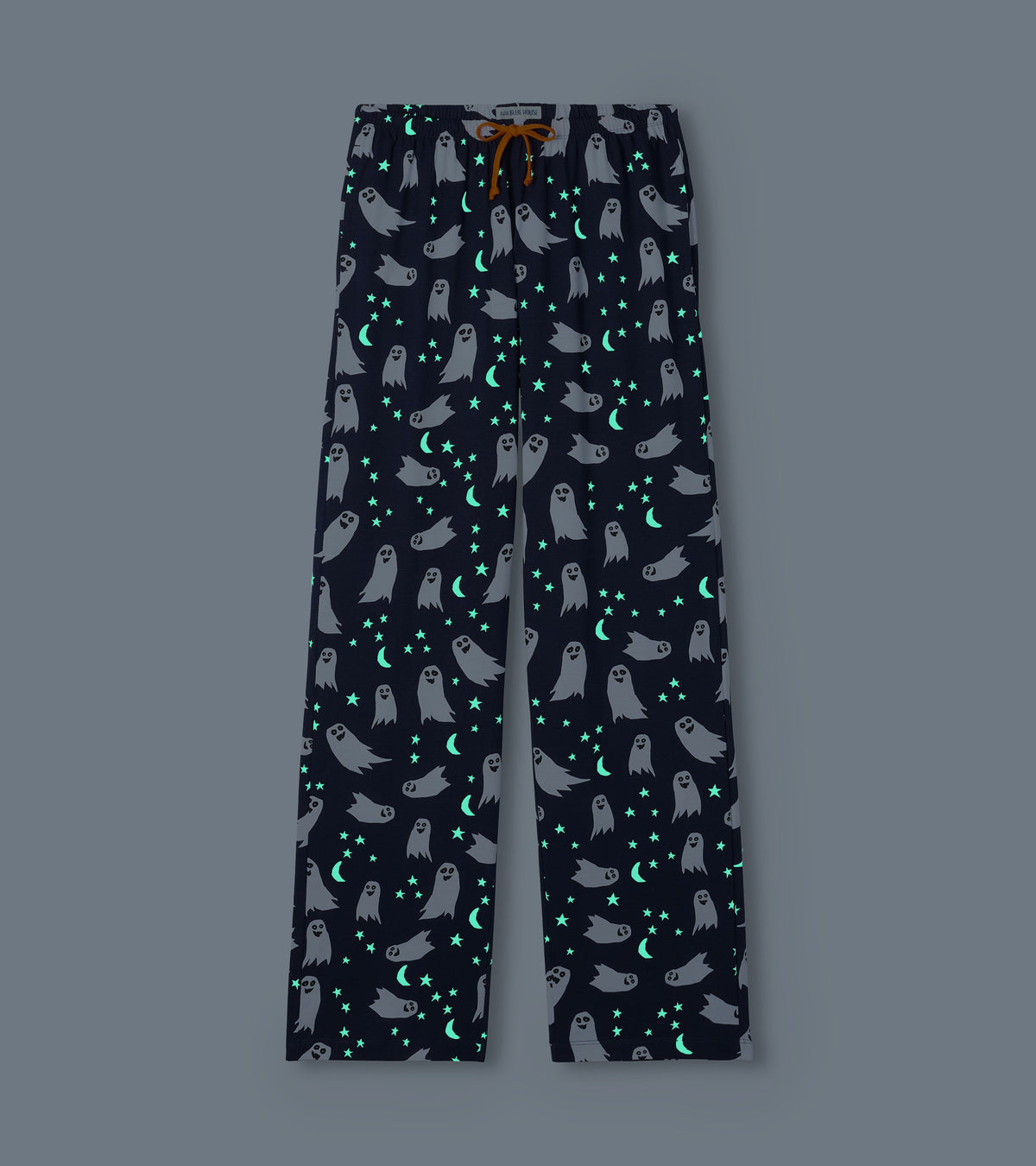 Navy ghost print pajama pants shown glowing in the dark with bright stars and crescent moons