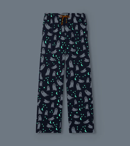 Navy ghost print pajama pants shown glowing in the dark with bright stars and crescent moons