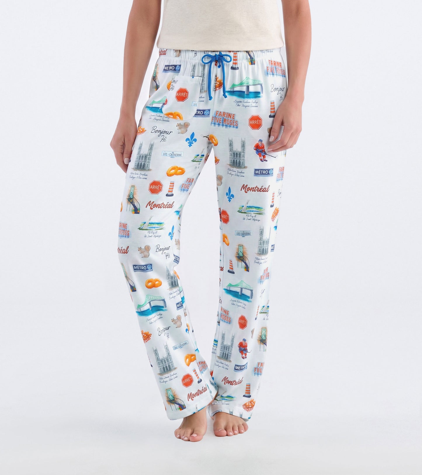 Front view of white Montreal pajama pants with blue drawstring and colorful city landmark print