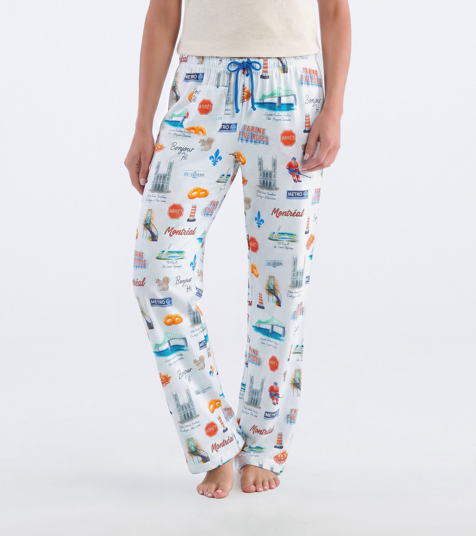Front view of white Montreal pajama pants with blue drawstring and colorful city landmark print