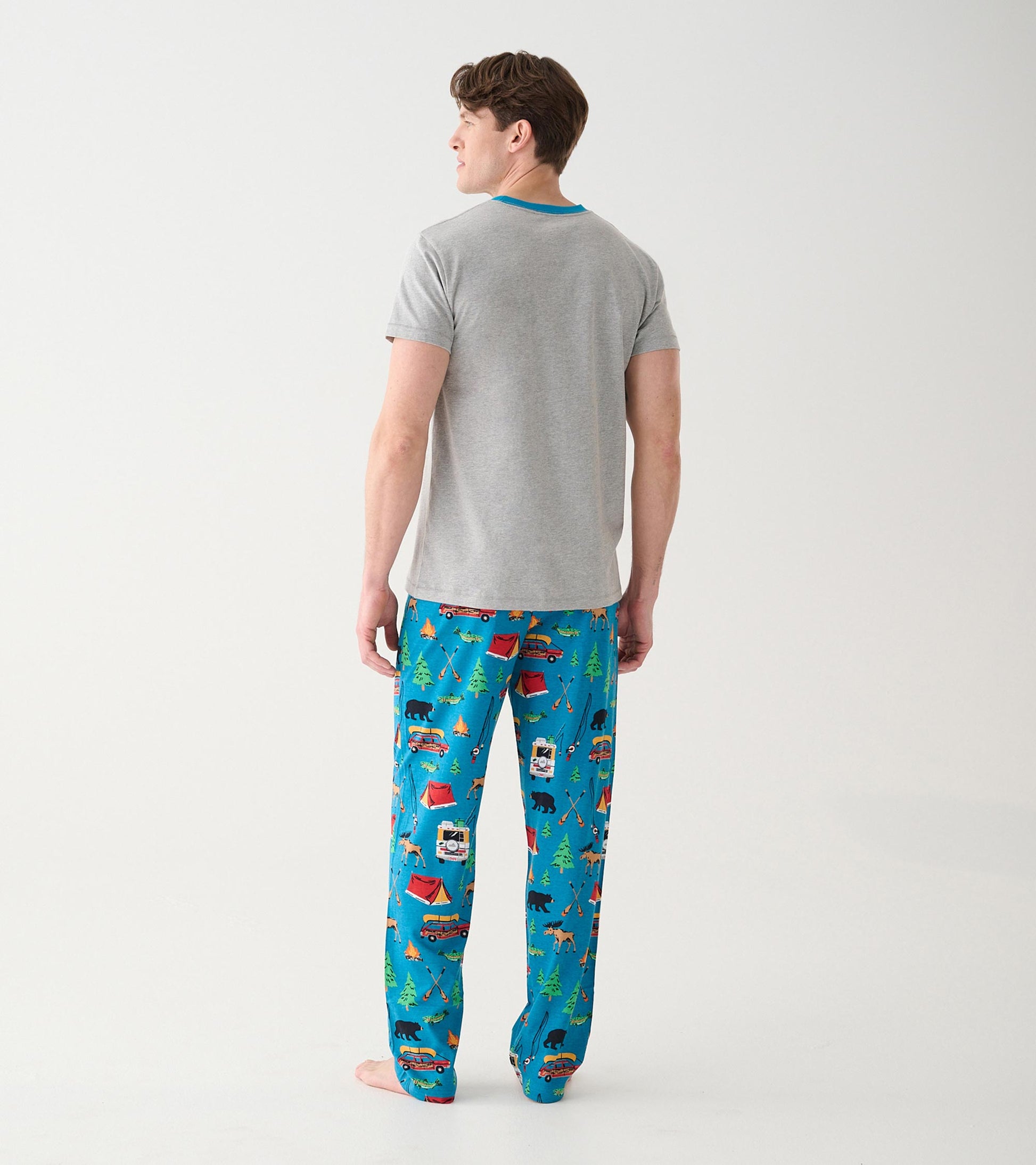 Back view of model wearing blue camping print pajama pants with a gray ringer T-shirt