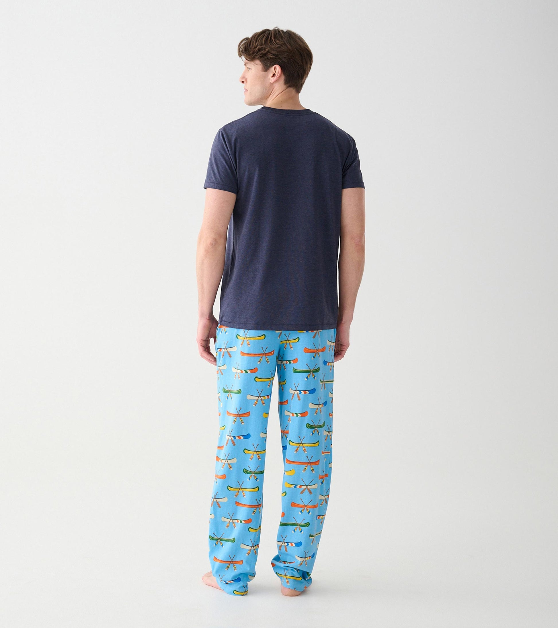 Men's blue canoe-print pajama pants shown with navy T-shirt, back view