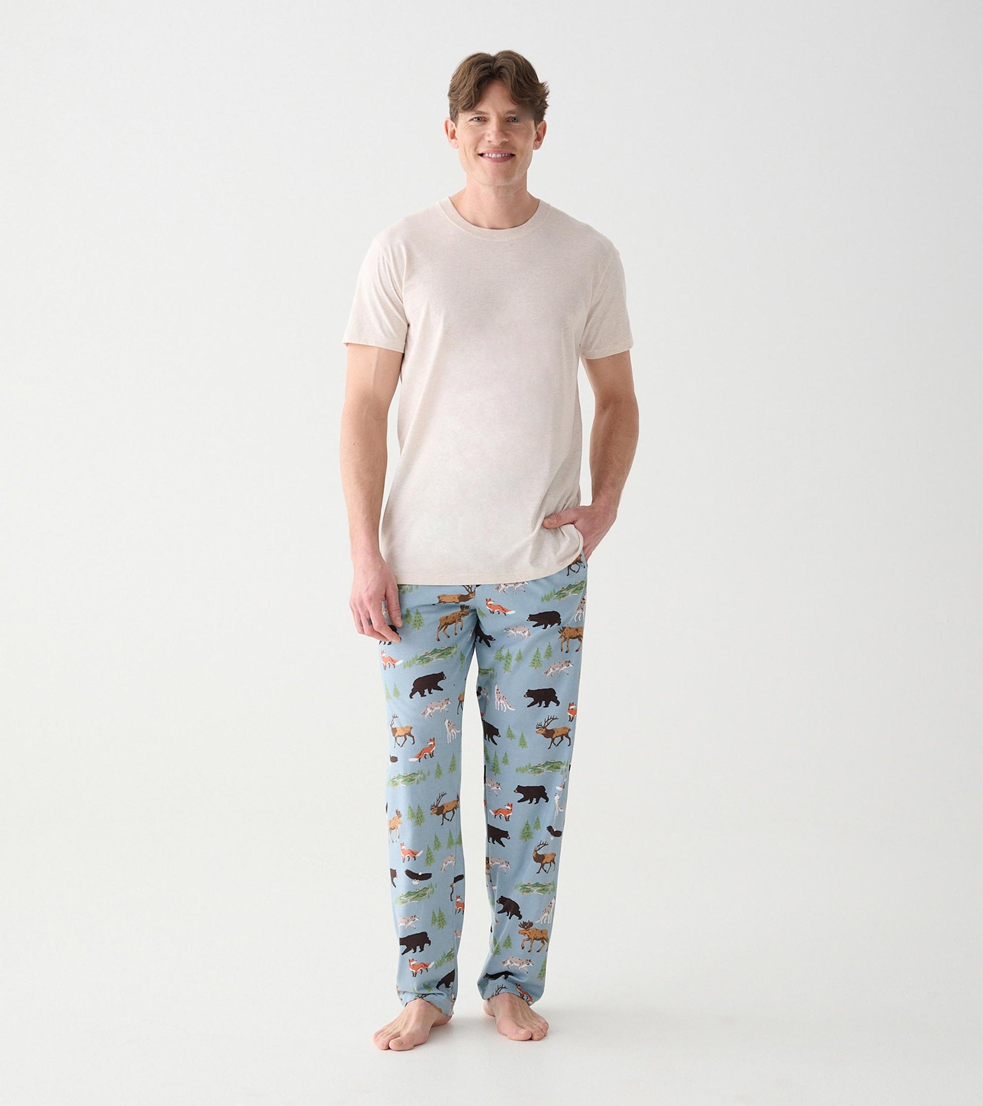 Model wearing light blue wilderness print pajama pants with a beige short sleeve tee, front view