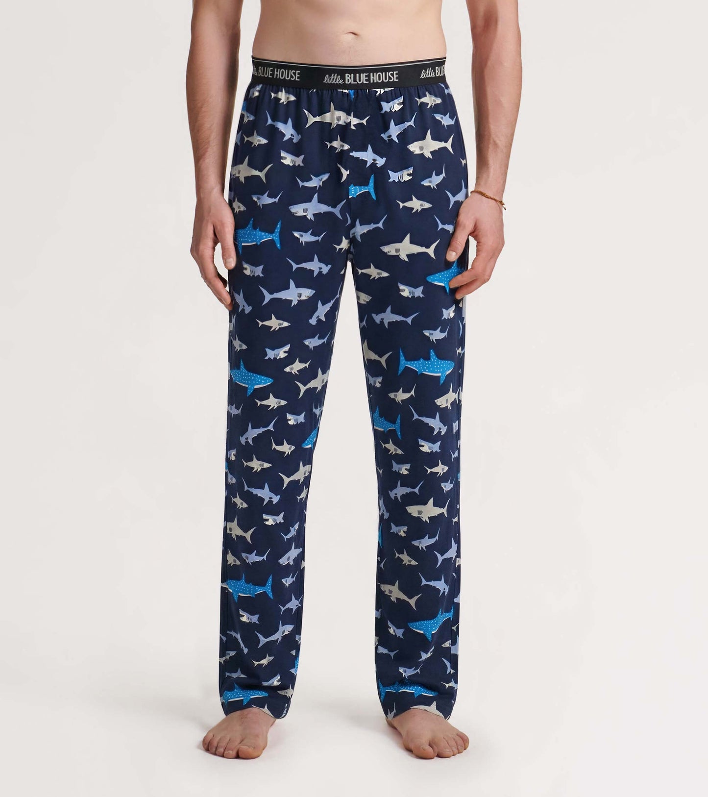 Men’s navy pajama pants with allover shark print and elastic waistband, front view.