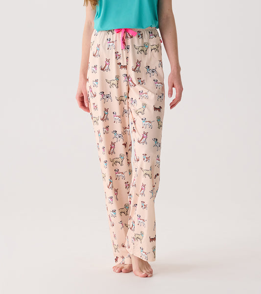 Model wearing cream pajama pants with colorful dog print and bright pink drawstring, front view