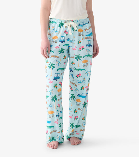 Close-up of light blue Florida print pajama pants with drawstring waist and palm trees, flamingos, gators, and golf carts