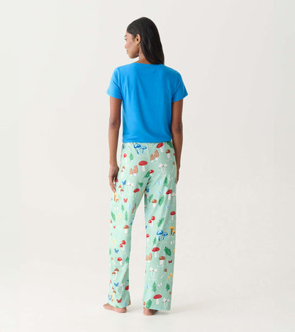 Back view of mint green pajama pants with colorful mushroom print, worn with a blue T-shirt.