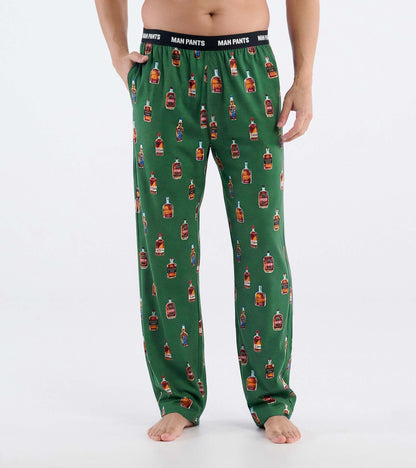Green pajama pants with whiskey bottle print and black elastic waistband, front view on model