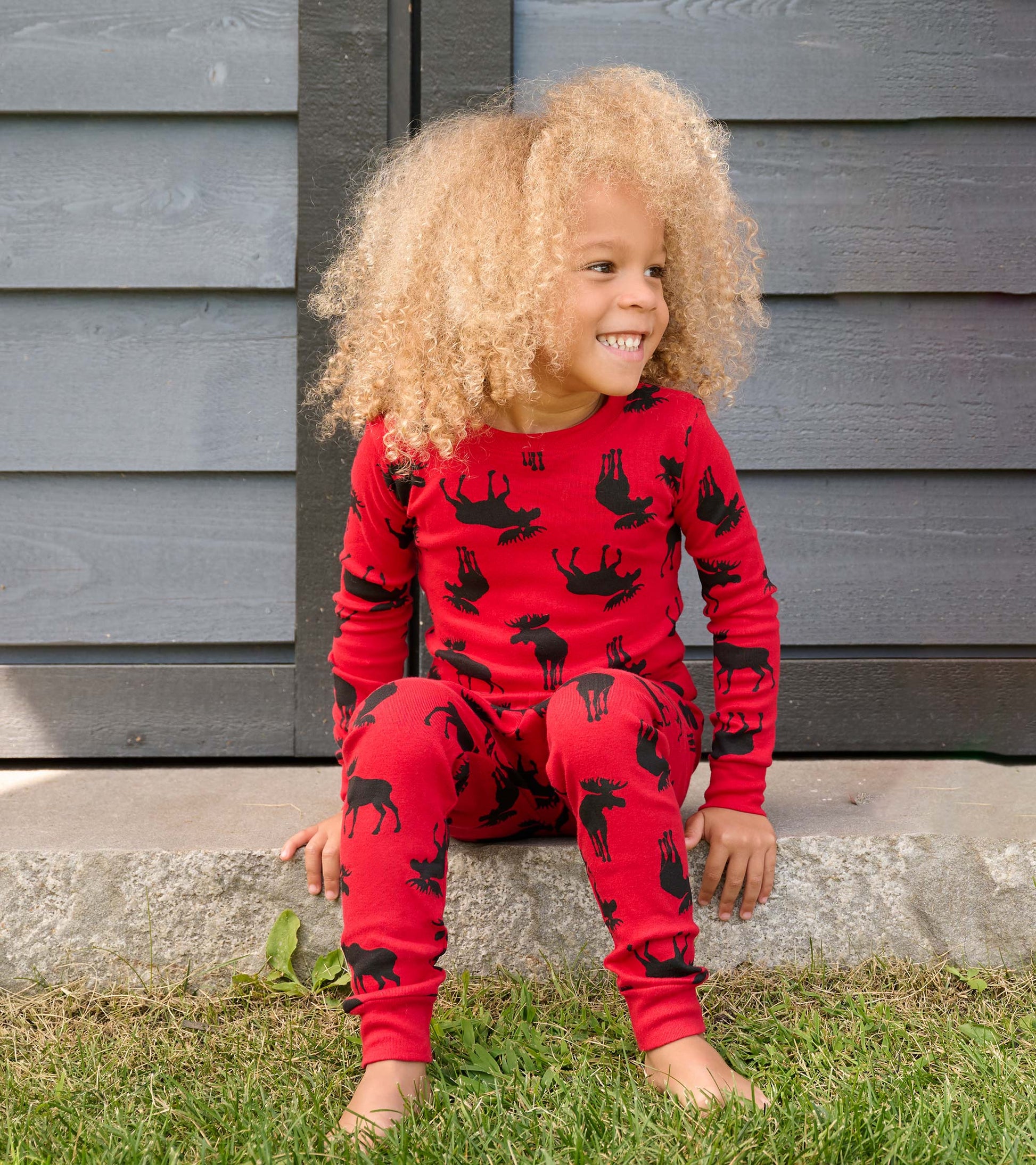 Red kids' pajama set featuring black moose patterns, designed for comfort and play.