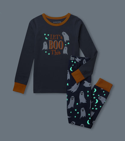 Kids pajama set shown in the dark with glowing stars and moons on ghost print pants and 'Let's Boo This' top