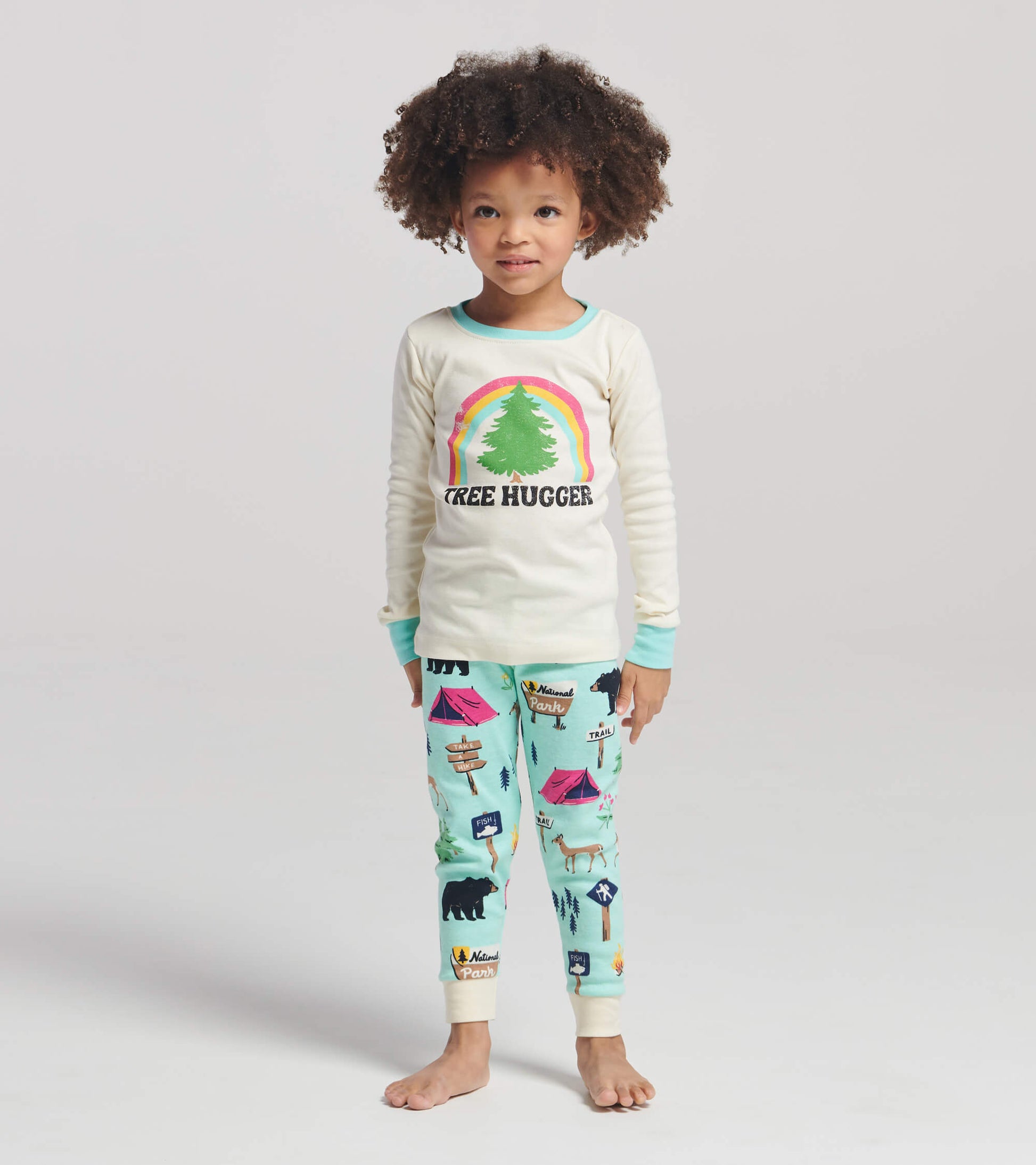 Cream long-sleeve top with "Tree Hugger" graphic, paired with aqua pajama pants featuring camping and wildlife prints.