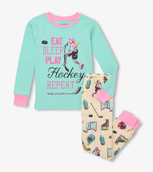 Kids hockey pajama set with mint top, pink cuffs, slogan graphic, and cream pants with hockey gear print