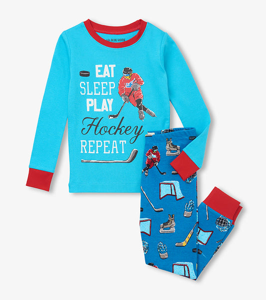 Blue kids pajama set with red trim, hockey player graphic top, and hockey gear print pants
