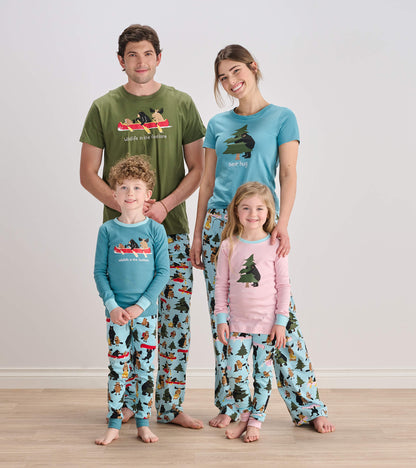 Family wearing matching woodland print pajamas; girl in pink bear hug pajama set at front right