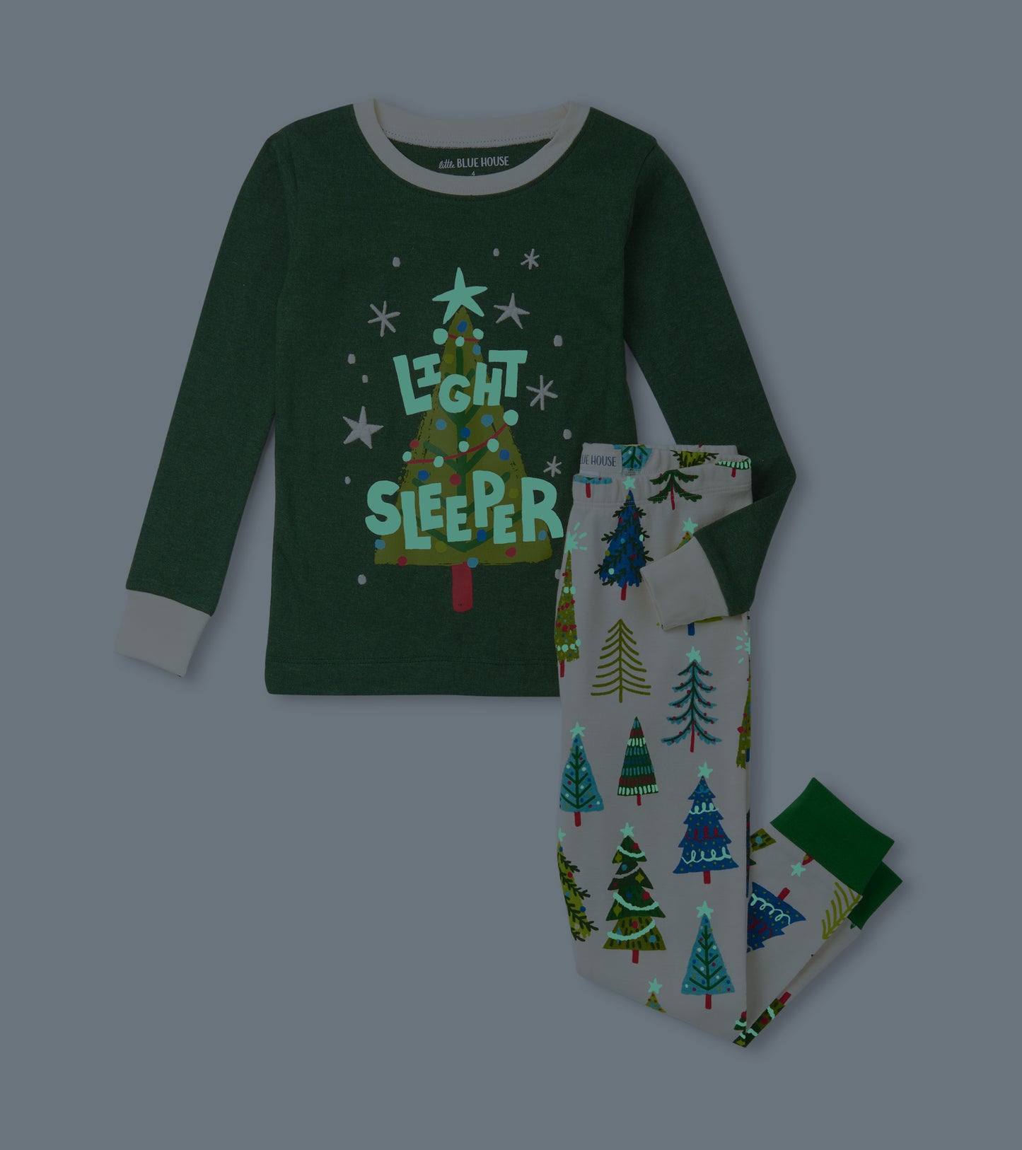 Green long-sleeve pajama top with "Light Sleeper" text, paired with white pants featuring colorful Christmas tree patterns.