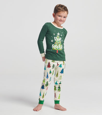 Green long-sleeve pajama top with "Light Sleeper" text, paired with cream pants featuring colorful Christmas tree patterns.