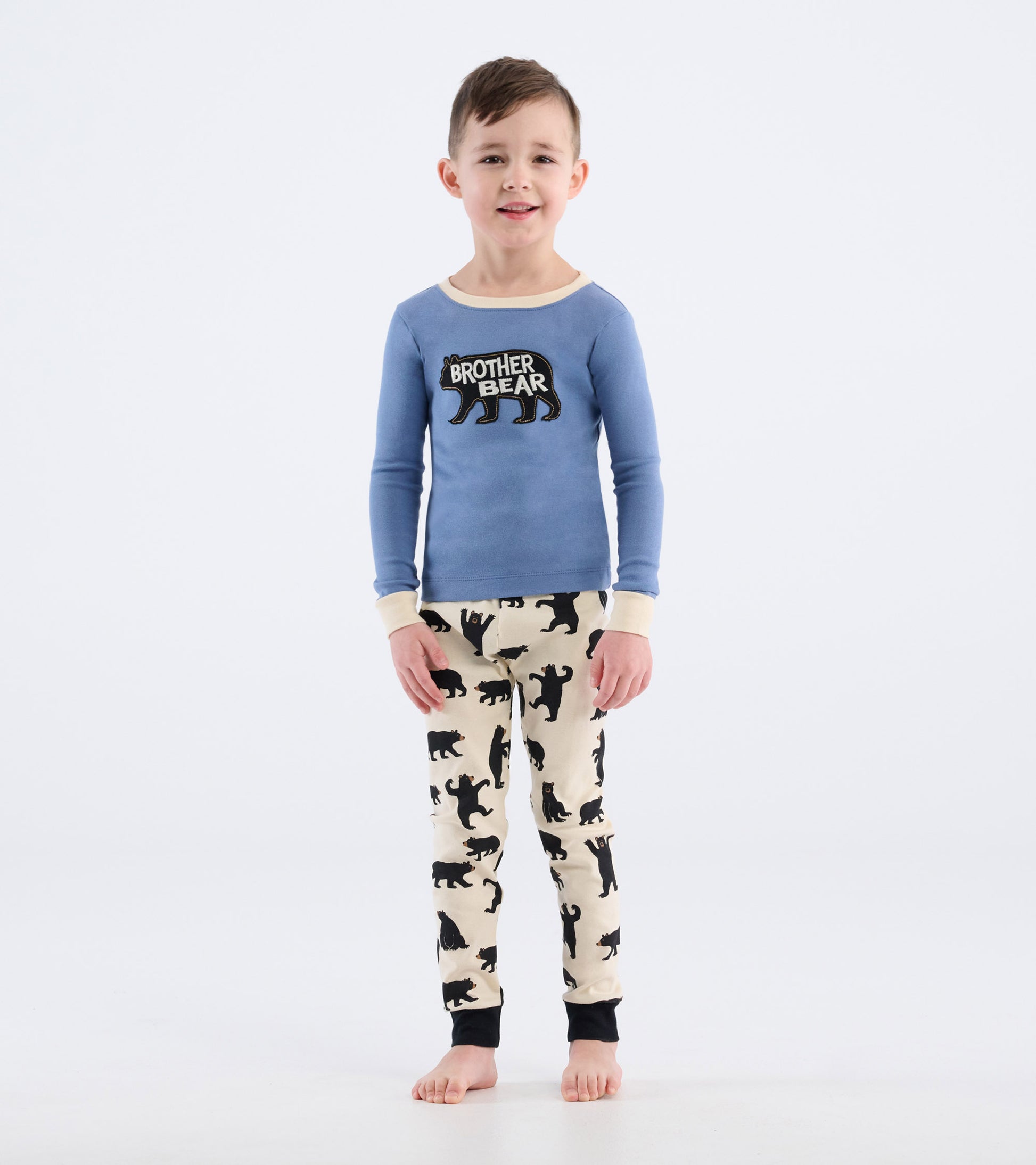 Blue long-sleeve pajama top with "Brother Bear" graphic, paired with cream pants featuring black bear silhouettes.