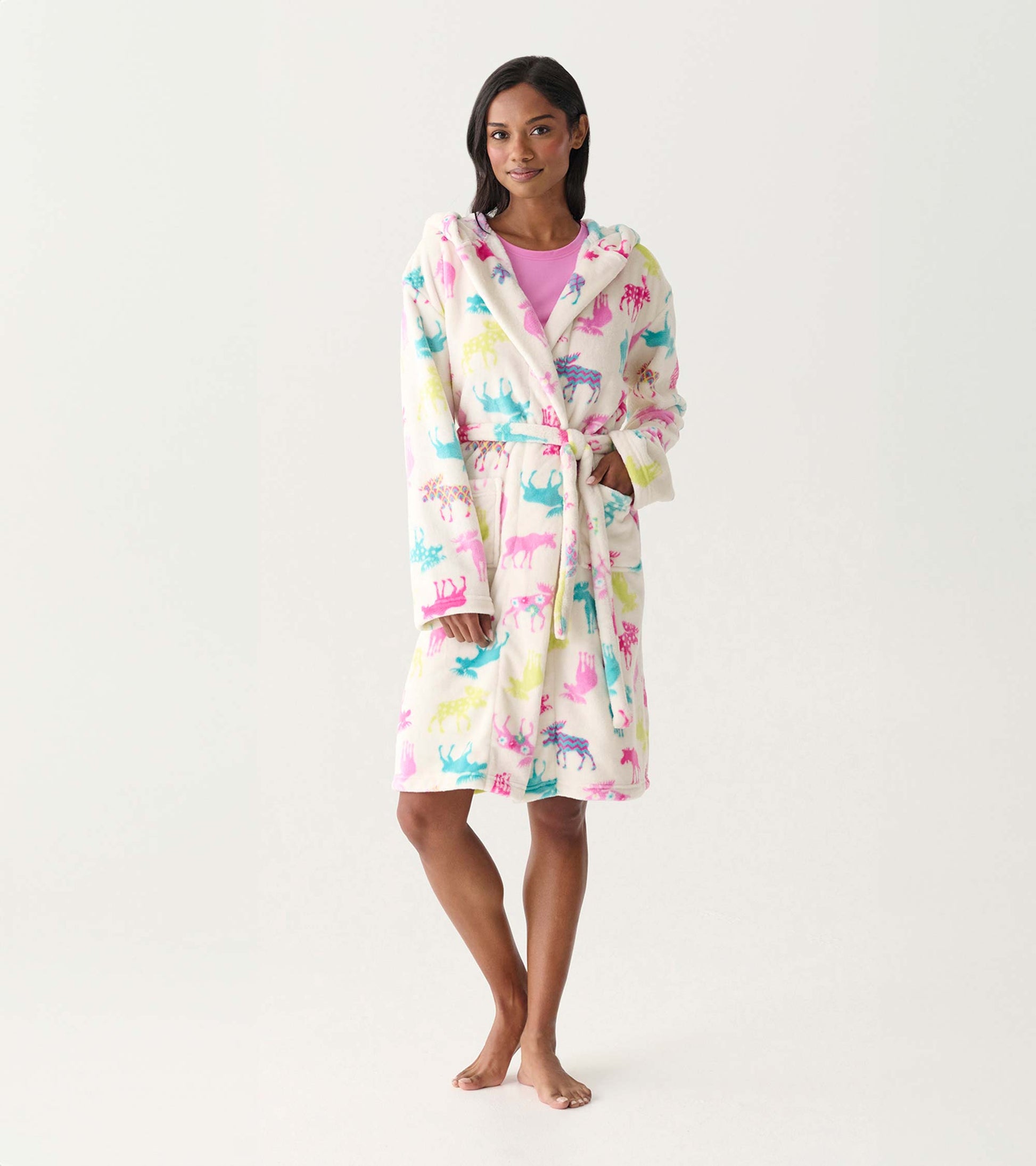 Women's white fleece robe with colorful moose print, hood, tie waist, and front pockets, worn on model