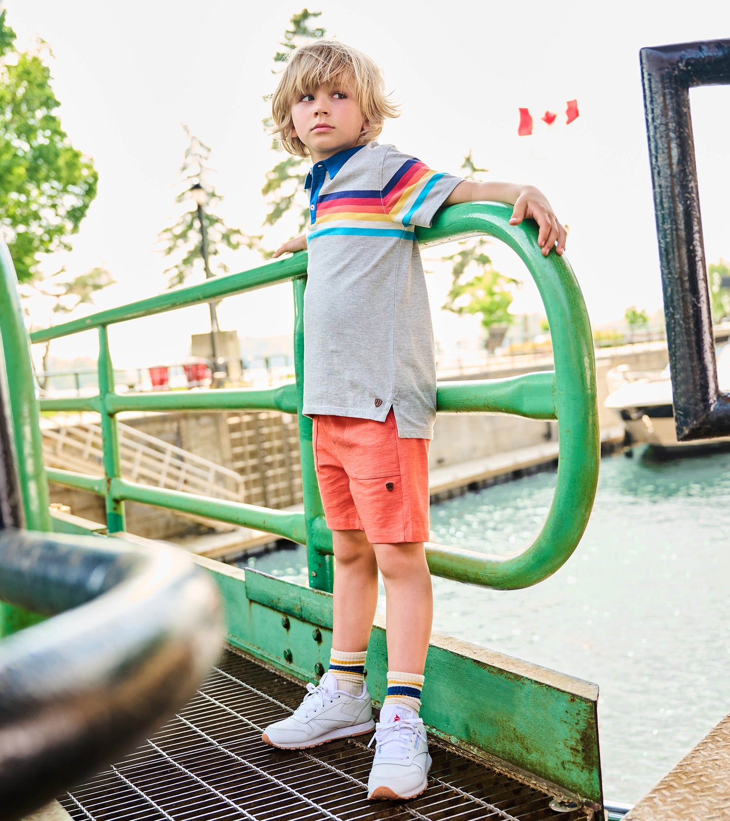 Coral boys shorts on a child, knee-length relaxed fit with side pockets and drawstring waist, front view