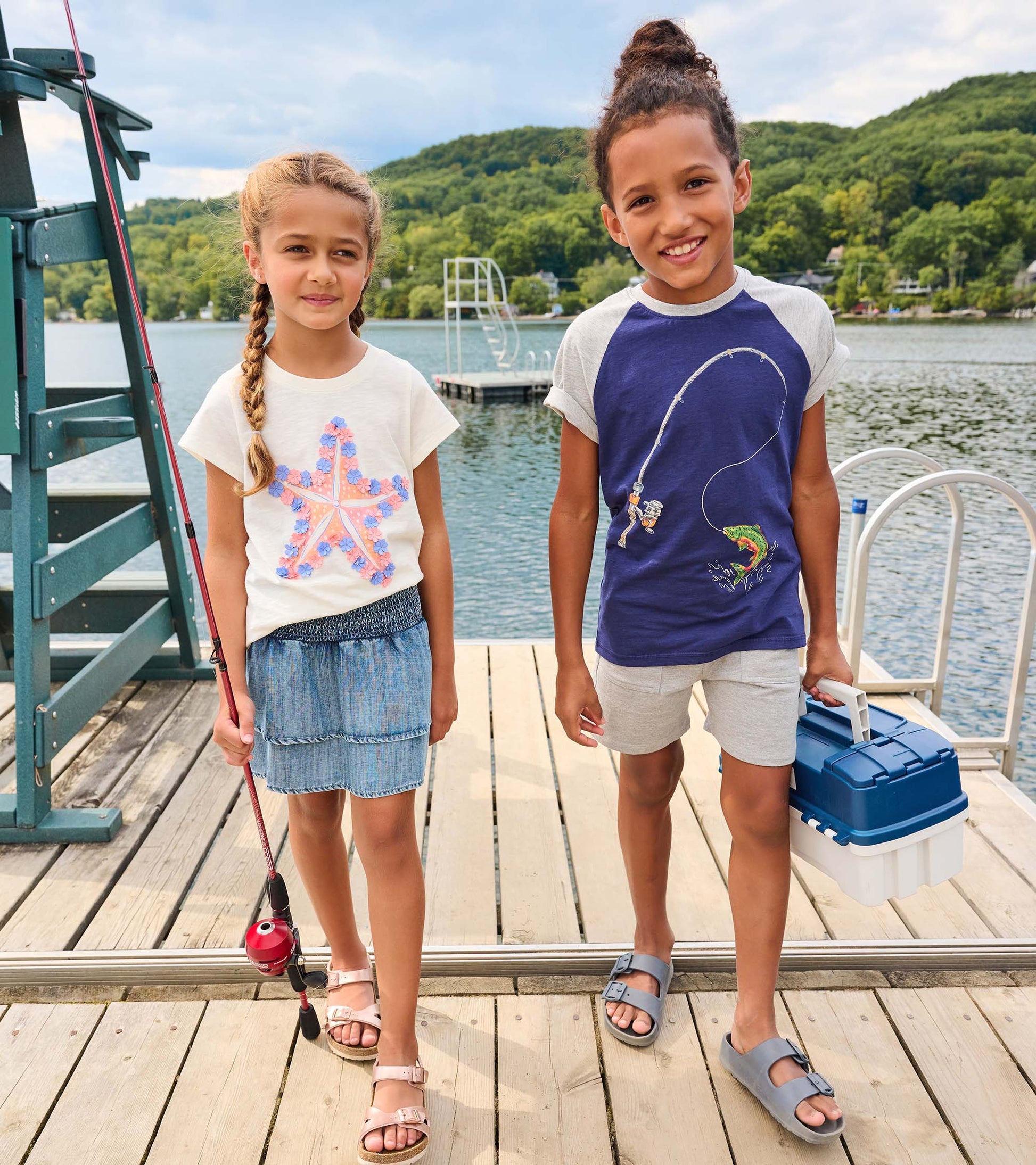 Light blue Tencel smocked skirt with layered design, worn by a girl on a dock near water, paired with a casual top.