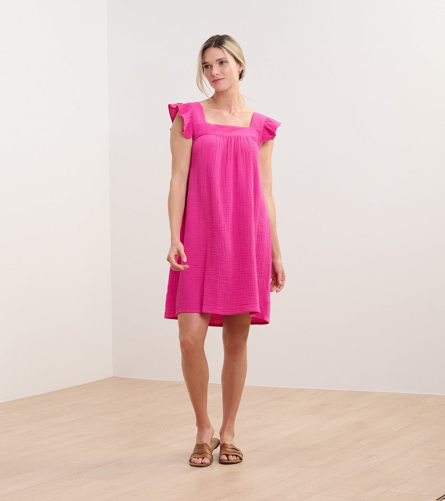Bright fuchsia sleeveless dress with flutter sleeves, square neckline, and relaxed knee-length fit on model