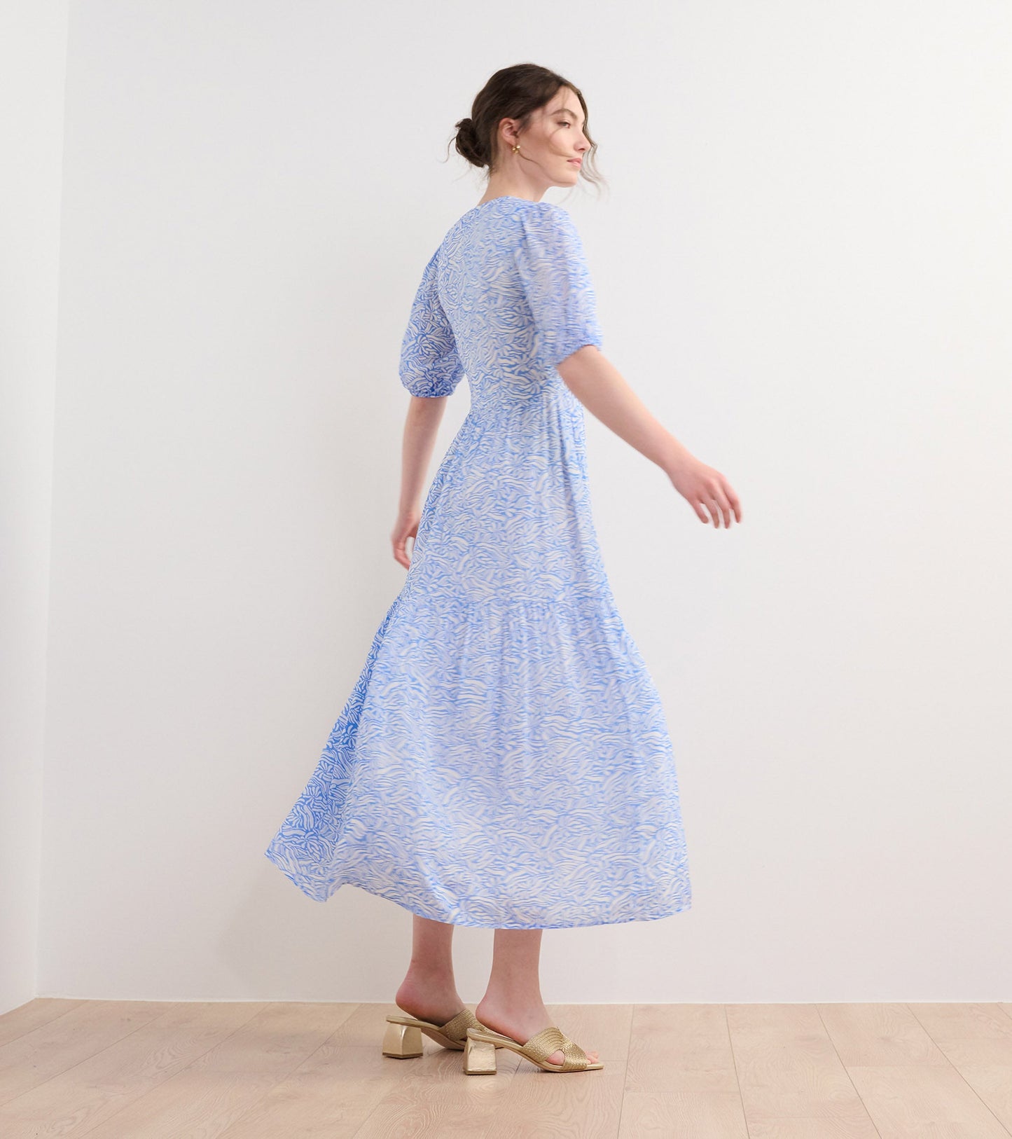 Light blue maxi dress with a groovy floral pattern, featuring puff sleeves and a flowing silhouette.