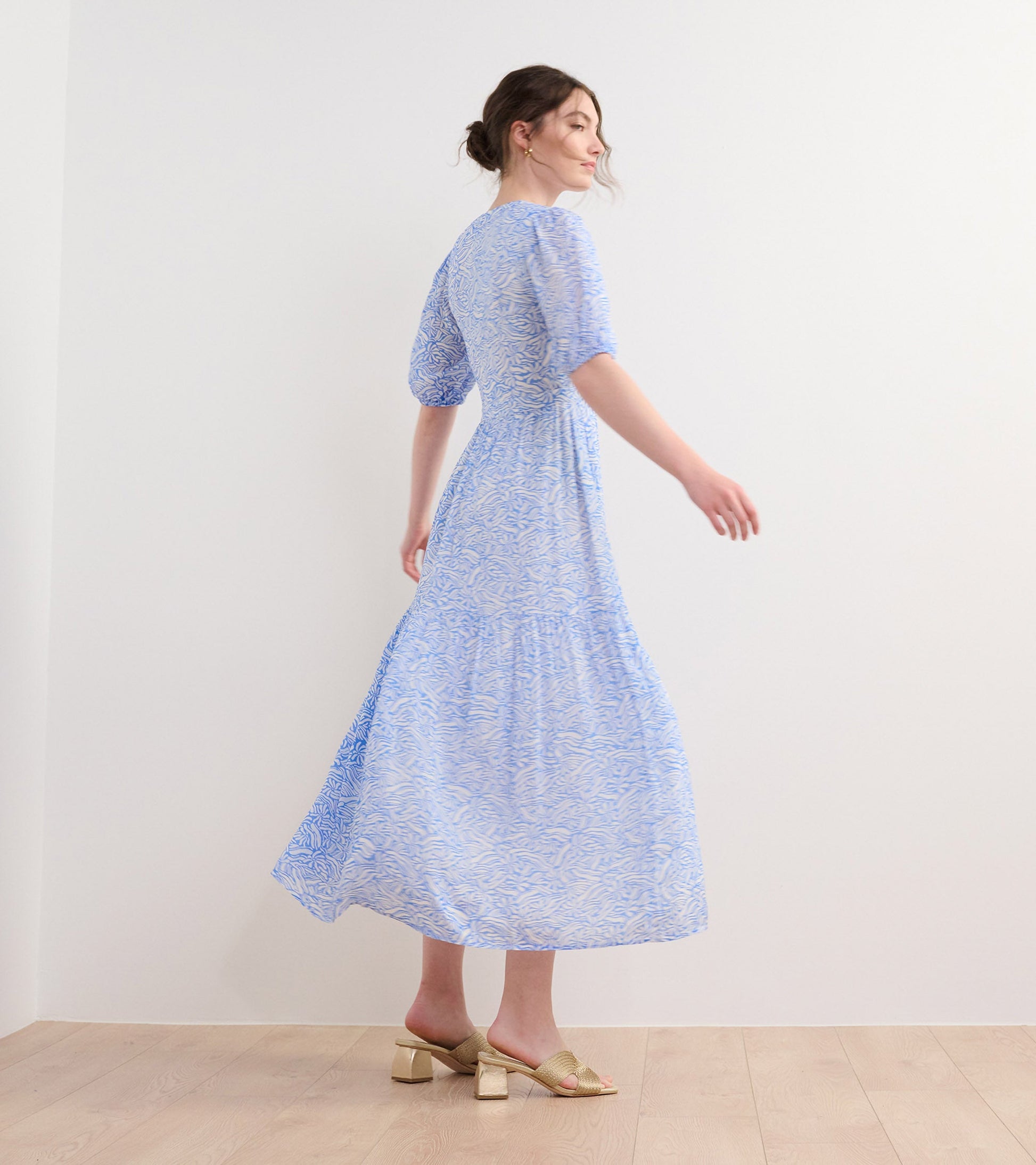 Light blue maxi dress with a groovy floral pattern, featuring puff sleeves and a flowing silhouette.
