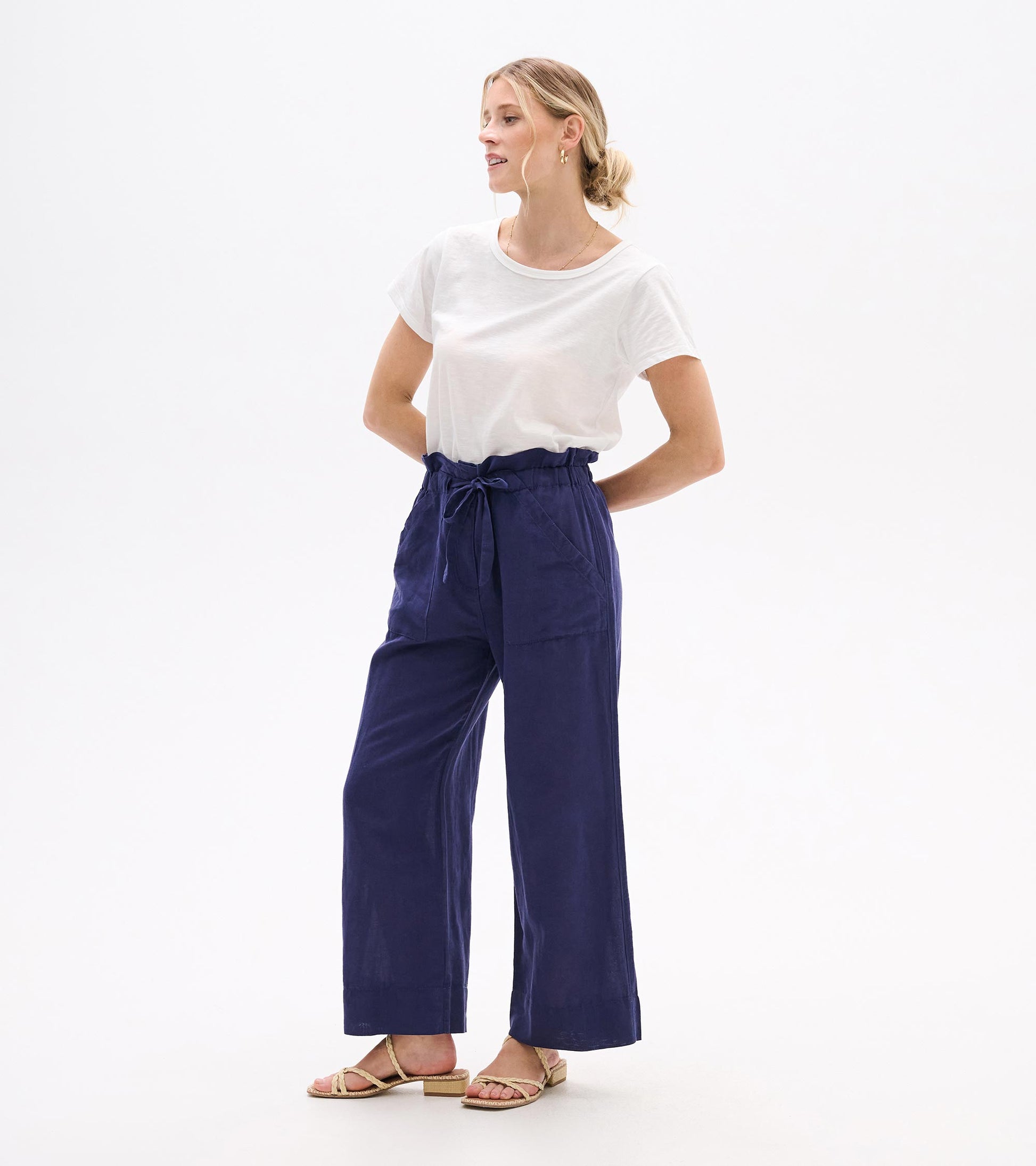 Woman wearing navy wide-leg tie-front pants with a high waist and cropped length, shown front view.
