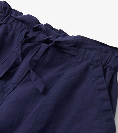 Close-up of navy blue pants with a tie waist and visible stitched seam details