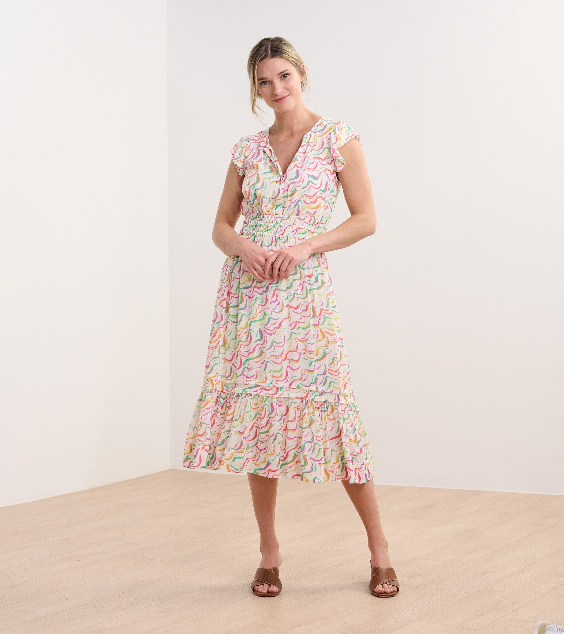 Floral midi dress with wavy stripes in pastel colors, featuring a V-neck and ruffled sleeves, perfect for casual wear.