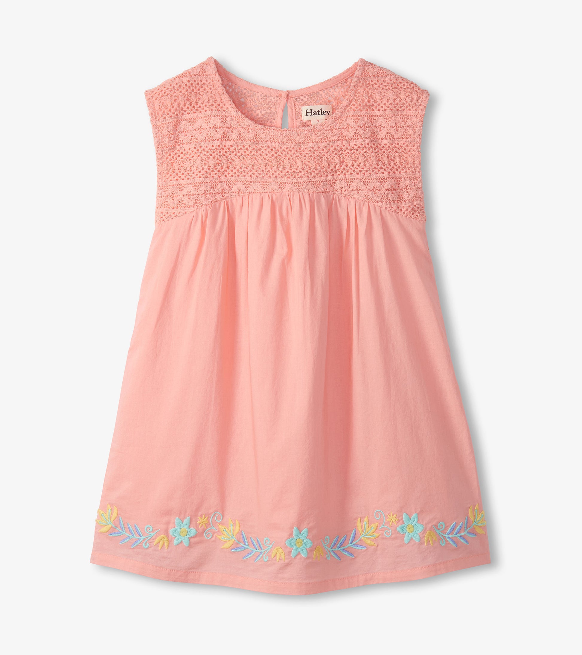 Front view of apricot blush girls dress with crochet bodice, gathered skirt, and embroidered floral hem