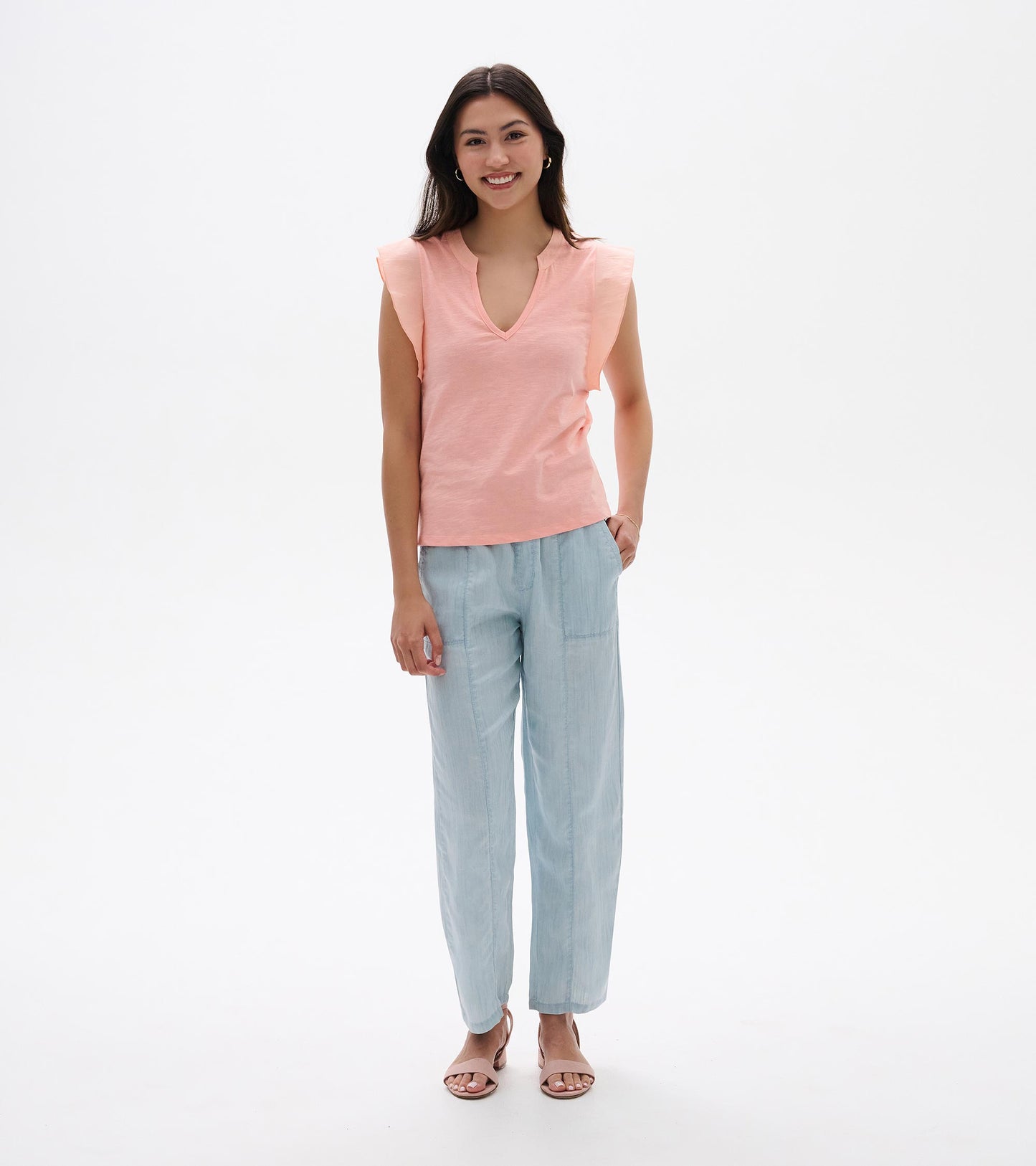 Apricot blush sleeveless V-neck tank top with flutter sleeves, shown on model front view