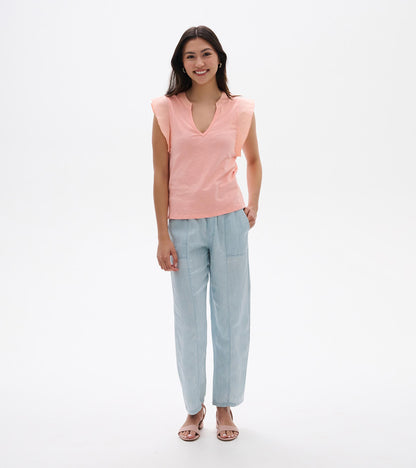 Apricot blush sleeveless V-neck tank top with flutter sleeves, shown on model front view