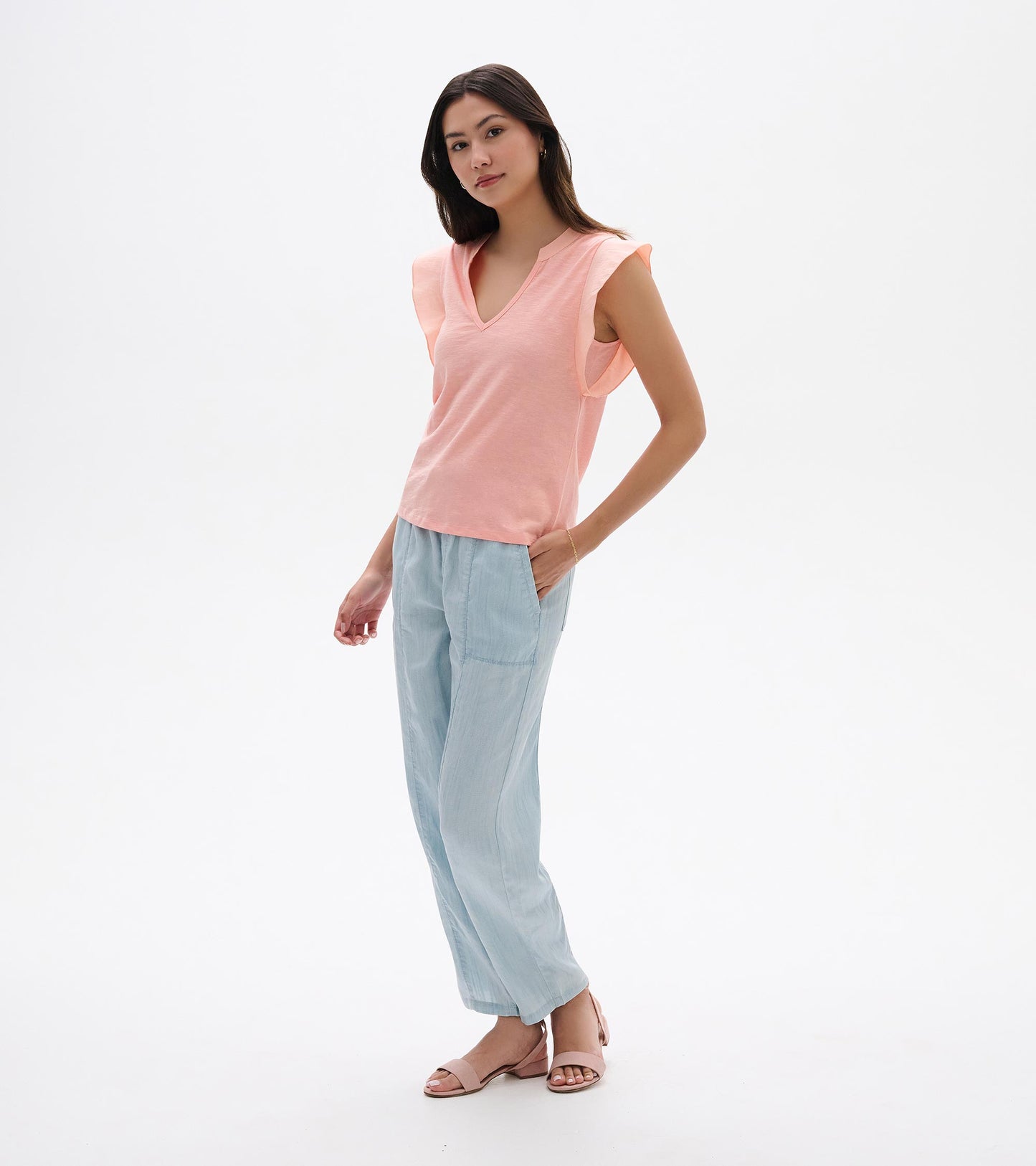 Apricot blush sleeveless V-neck tank top with flutter sleeves, shown on a model front view