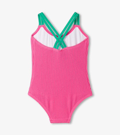 Girls hot pink ribbed one-piece swimsuit with green crisscross straps, front view