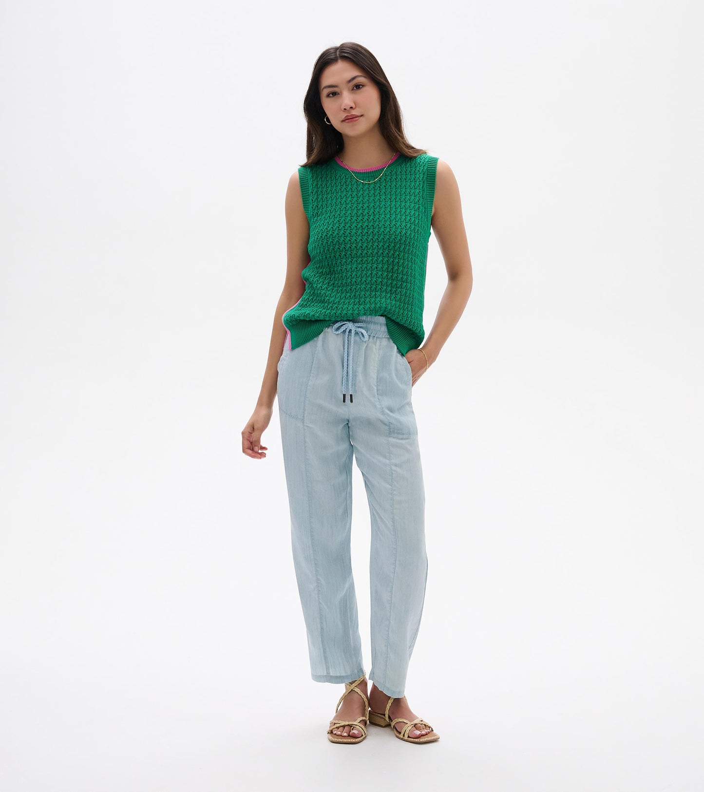 Green sleeveless knit tank top with ribbed trim and pink neckline, shown on a model front view