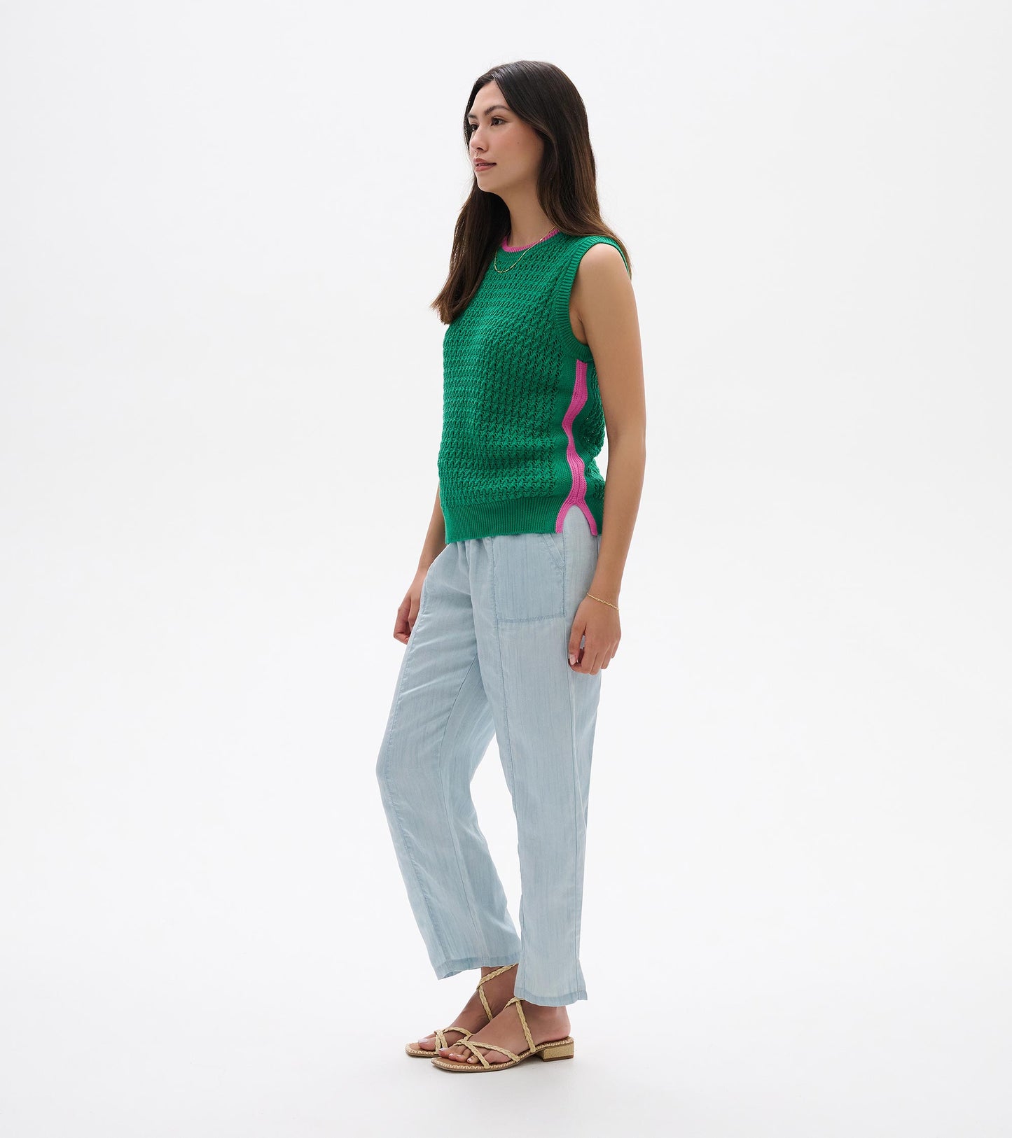Green knit sleeveless tank top with pink side trim, shown on a model in side view.