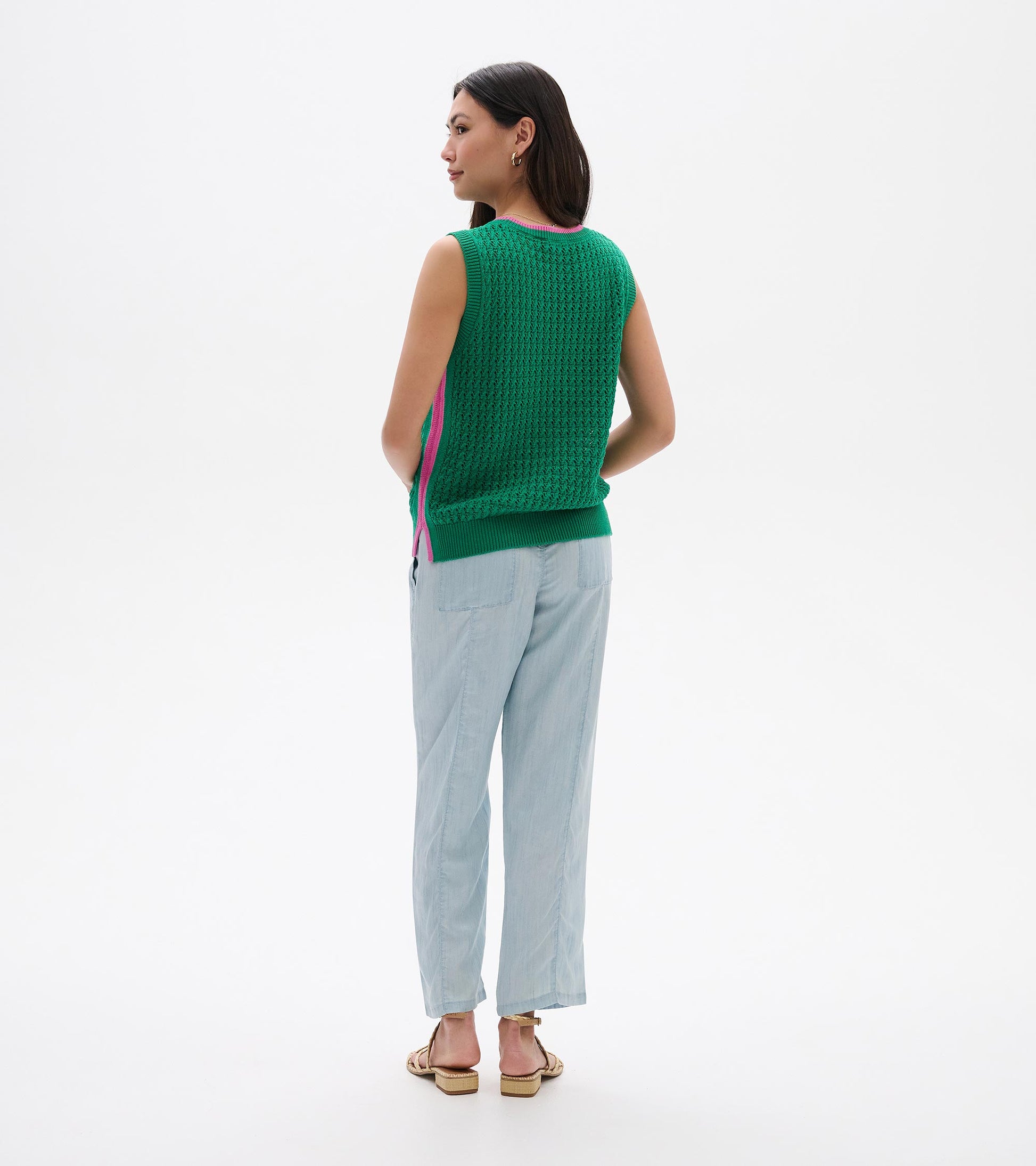 Green knit sleeveless tank top with pink trim, shown from the back on a model
