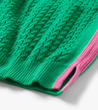 Green knit tank top with textured cable pattern and pink trim detail, close-up view