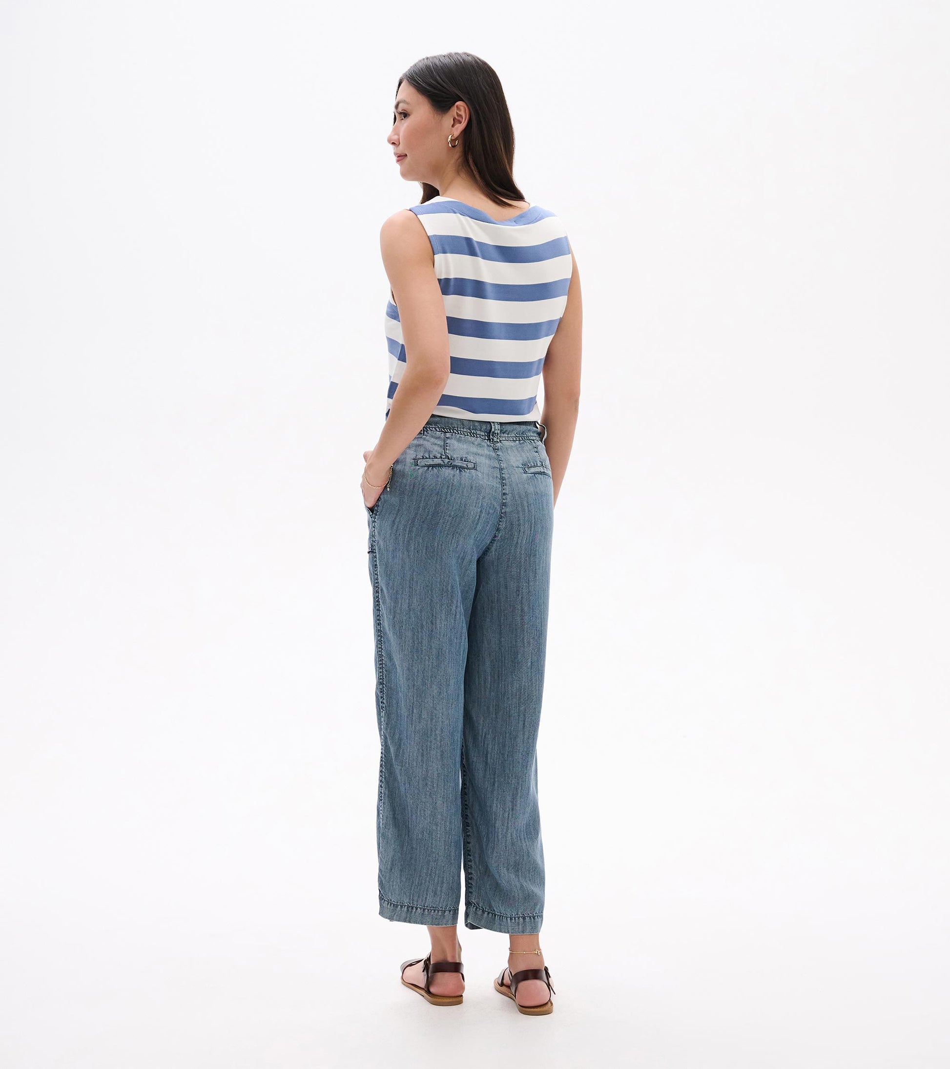 Back view of blue acid-wash wide-leg cropped pants with a relaxed fit and denim texture