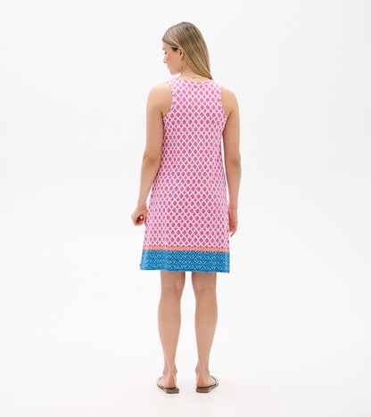 Back view of a sleeveless pink patterned dress with blue geometric hem and white trim.