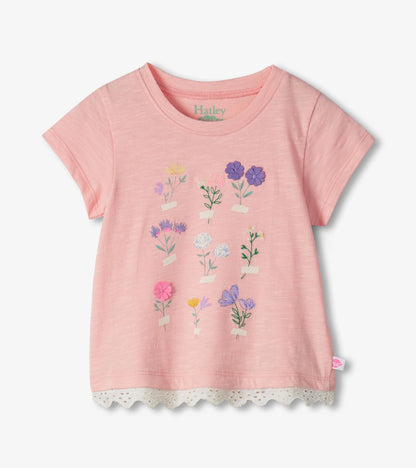 Pink short-sleeve toddler T-shirt with floral print and lace-trim hem, front view
