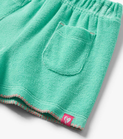 Mint green terry cloth shorts with elastic waistband, back pocket, and pink stitched hem detail