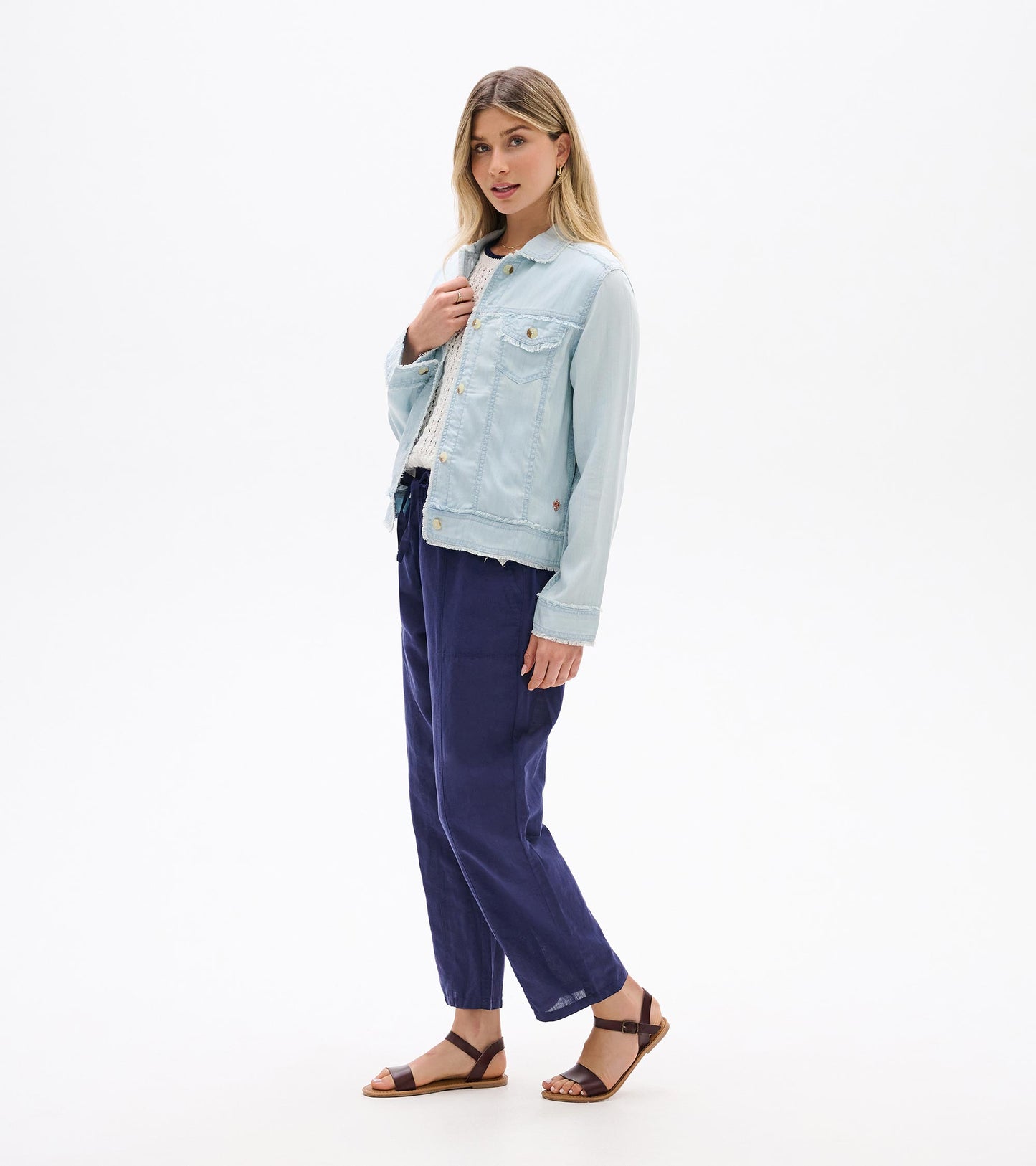 Light blue denim-style jacket with button front, chest pockets, and long sleeves, worn open on a model.