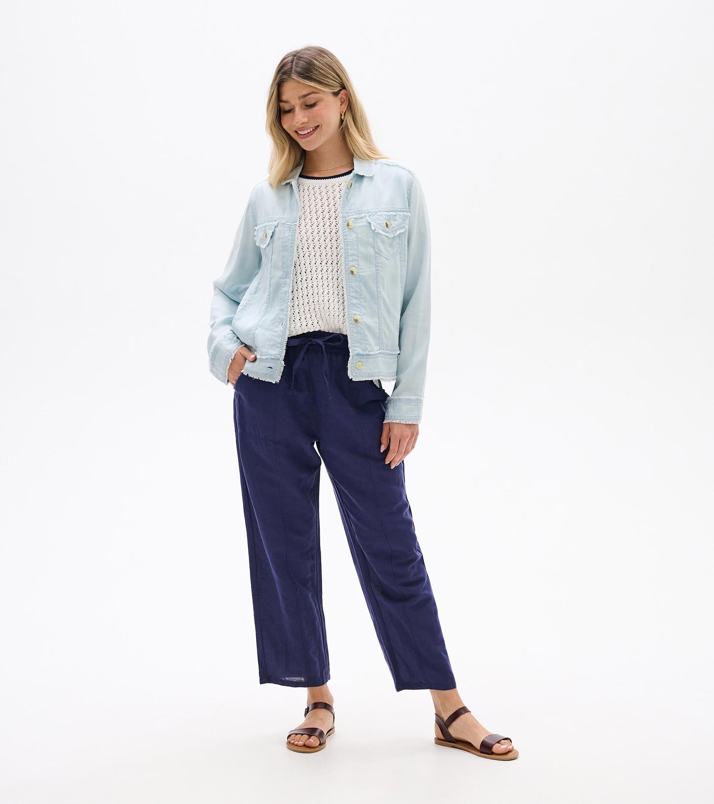 Light blue denim-style jacket with button front, chest pockets, and long sleeves, worn open on a model.