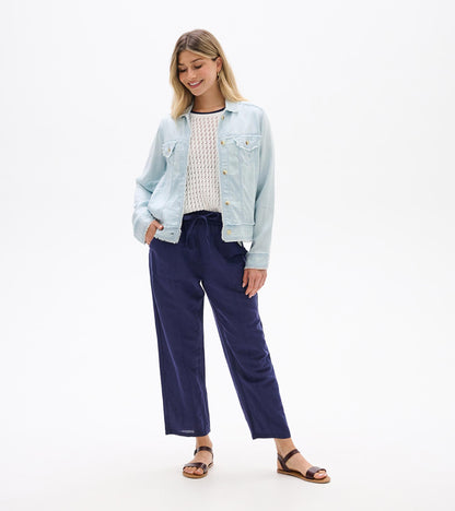 Light blue denim-style jacket with button front, chest pockets, and long sleeves, worn open on a model.