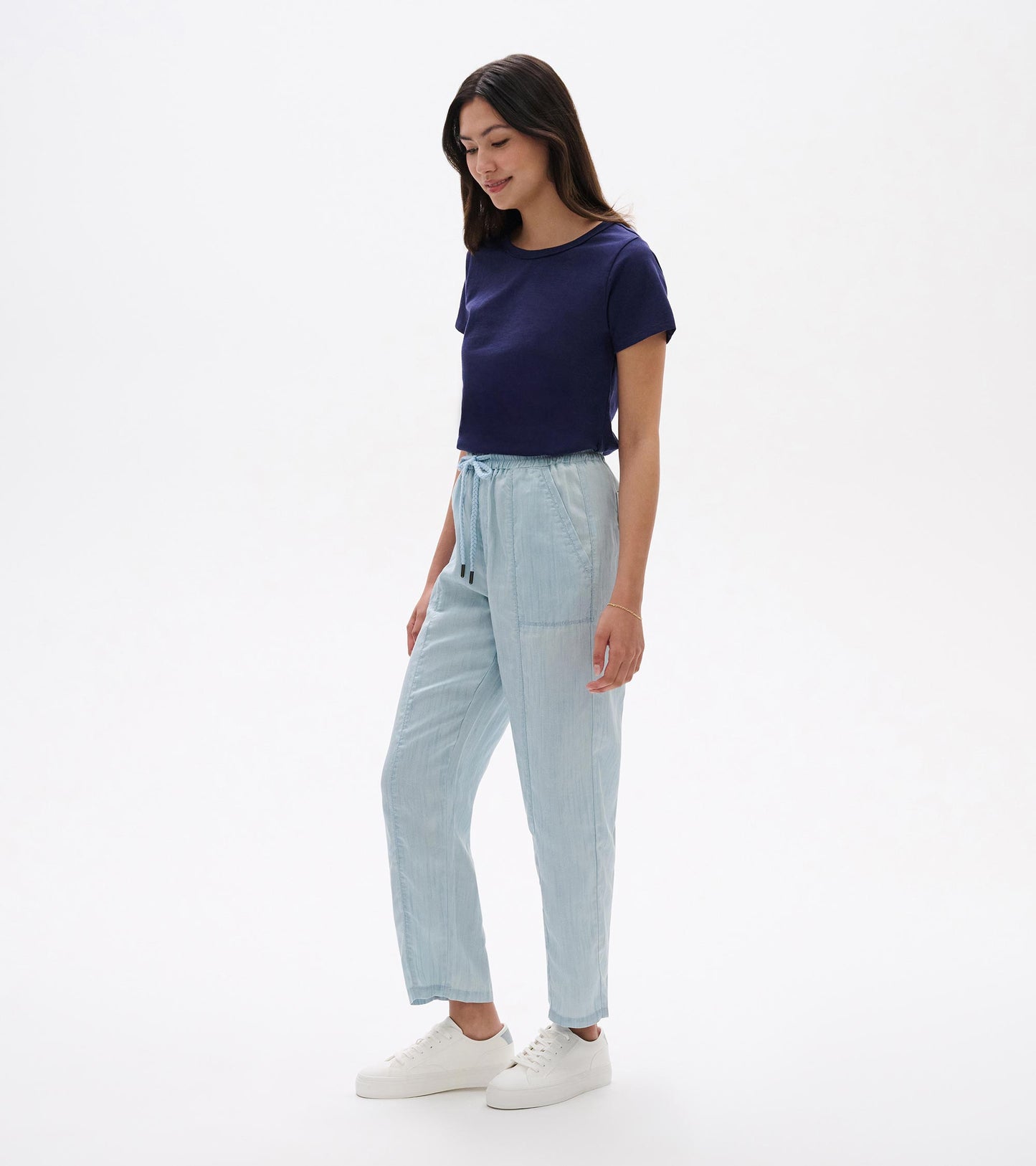 Light blue straight-leg pants with an elastic drawstring waist, shown on a model with white sneakers.