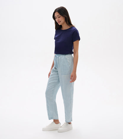 Light blue straight-leg pants with an elastic drawstring waist, shown on a model with white sneakers.